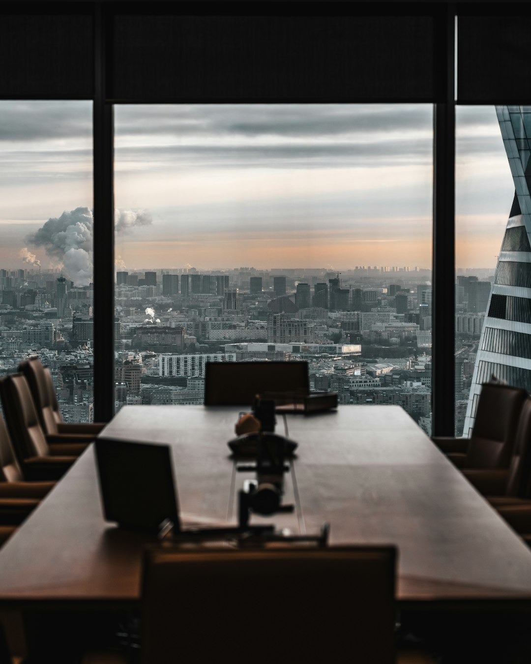Empty conference room with city view through large windows.